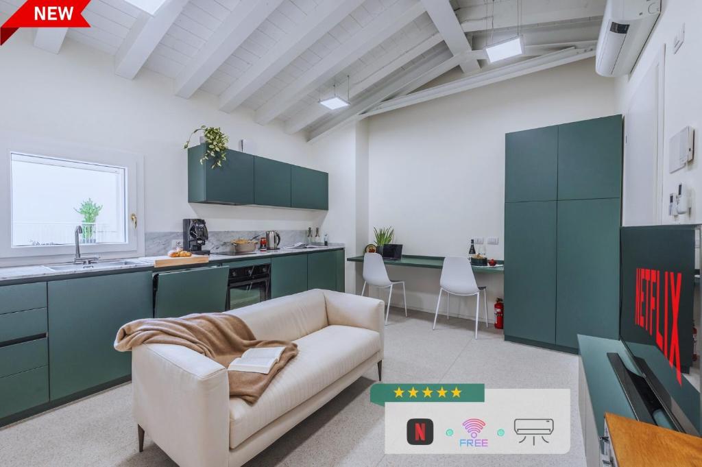 a living room with a couch and a kitchen at Loft Design Free Parking - Maranello - Sassuolo in Casalgrande