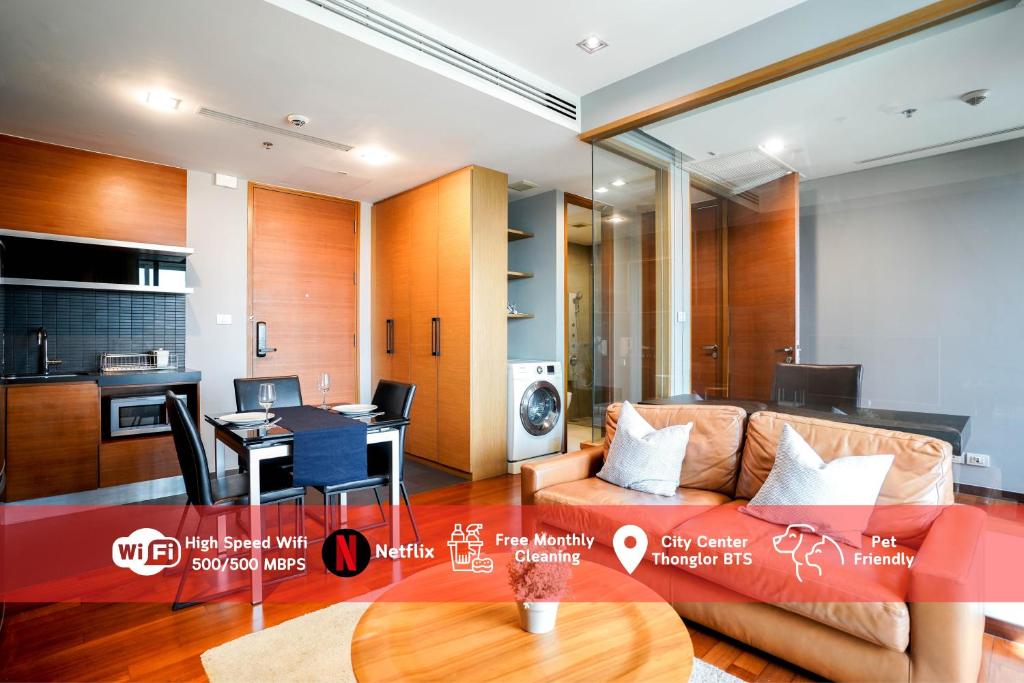 a living room with a couch and a table at Thonglor Modern Luxury Condo in Bangkok