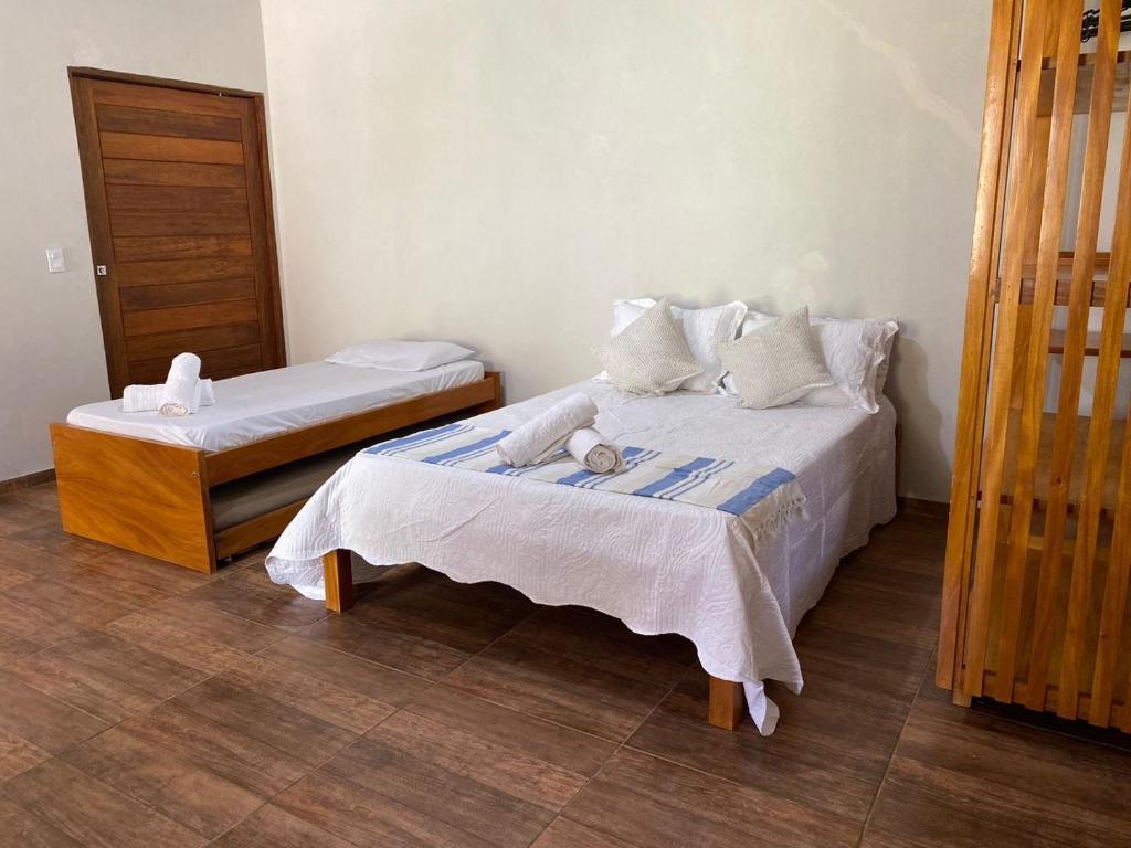 - une chambre avec 2 lits et une porte en bois dans l'établissement Vila dos Anjos Itacaré, à Itacaré