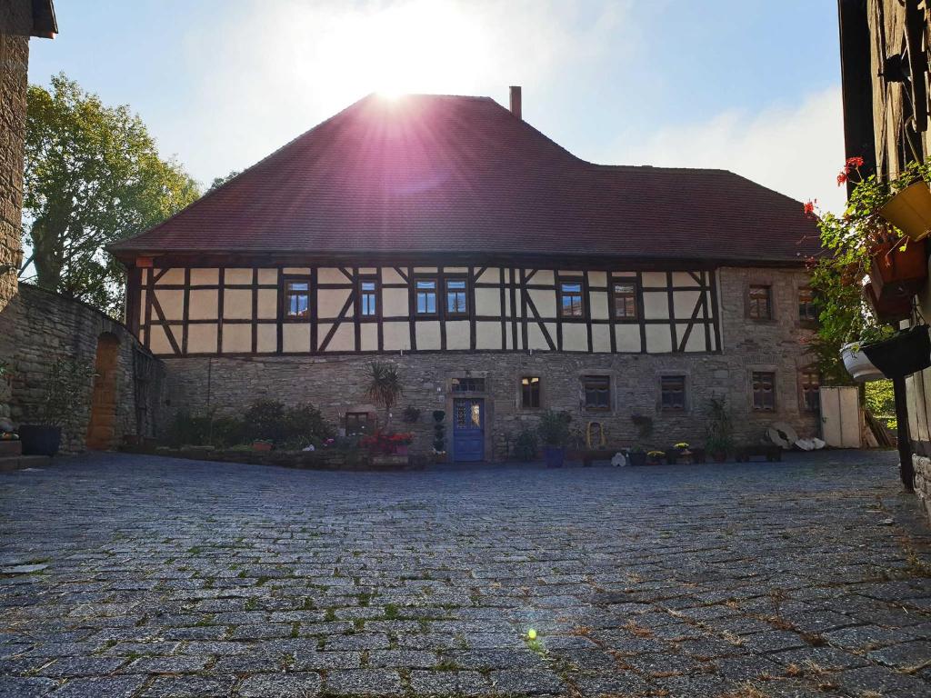 a building with a roof with the sun shining on it at Pension Stadtmühle Allstedt in Allstedt