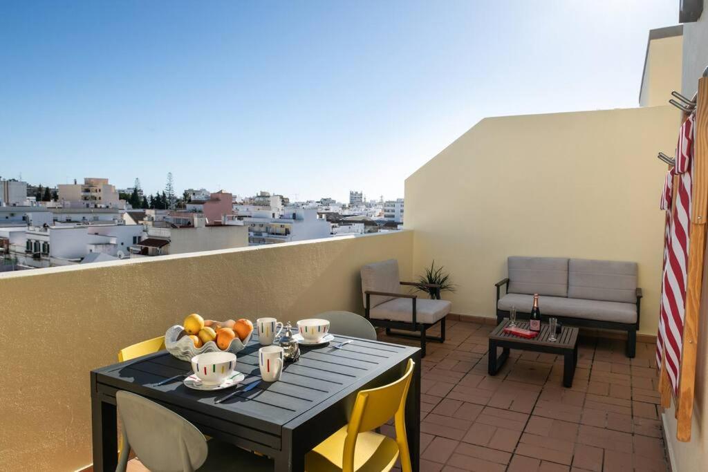 een tafel en stoelen op een balkon met uitzicht bij Penthouse Olhão with terrace in Olhão