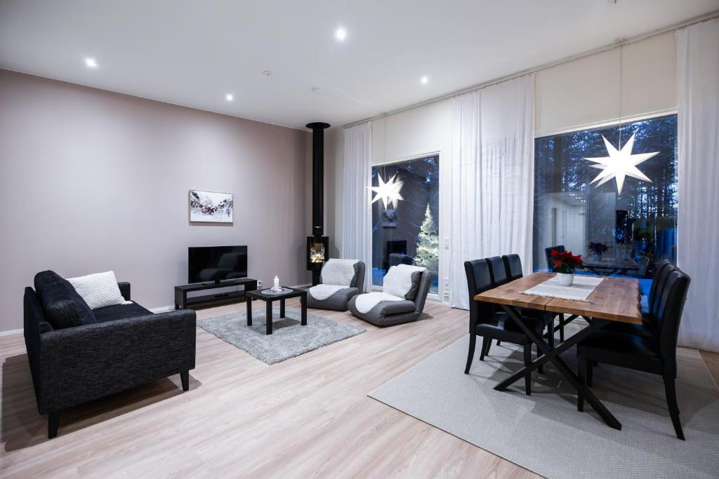 een woonkamer met een tafel en stoelen bij Brand new Arctic snowstar apartment in Rovaniemi