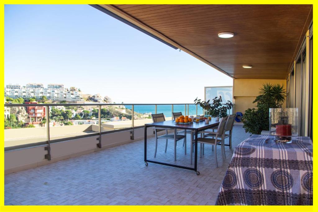 a balcony with a table and a view of the ocean at Cullera Beach Apartment Cap Blanc in Cullera