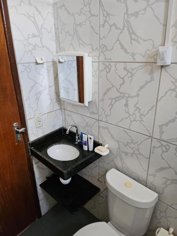 Un baño con un inodoro blanco y un lavabo. en Casa da Mãe Barra Grande, en Maragogi
