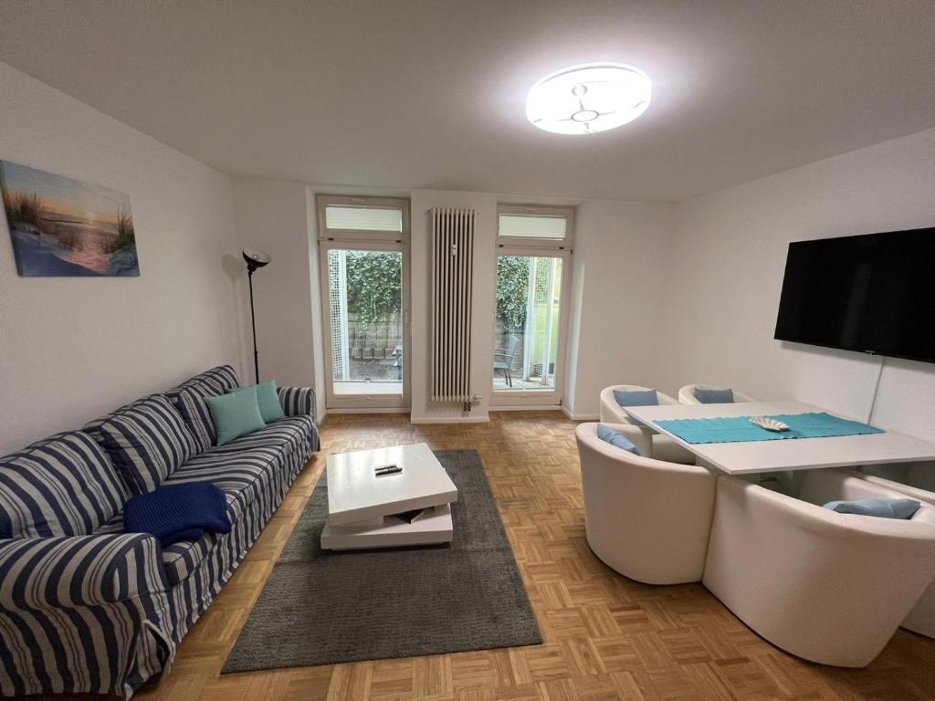 uma sala de estar com um sofá e uma mesa em Apartment BERNSTEIN ruhig, familienfreundlich mit Garten em Rostock