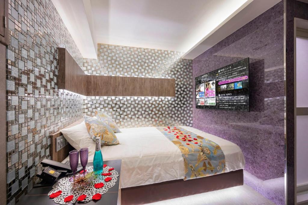 a bedroom with a bed and a purple wall at Exquisite business hotel Bella in Tokyo