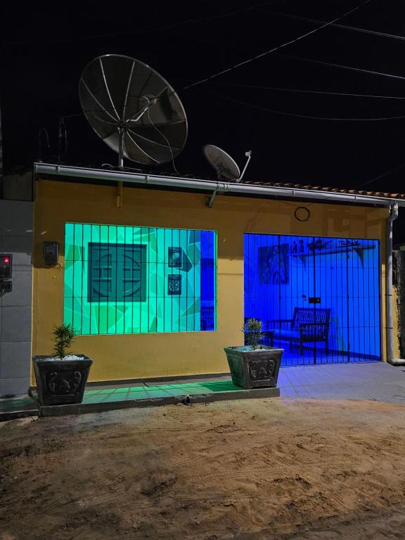 マラゴージにあるCasa da Mãe Barra Grandeの青と緑の窓と衛星が備わる家