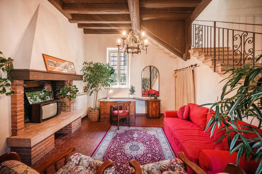 a living room with a red couch and a fireplace at Villa Calicantus in Bardolino