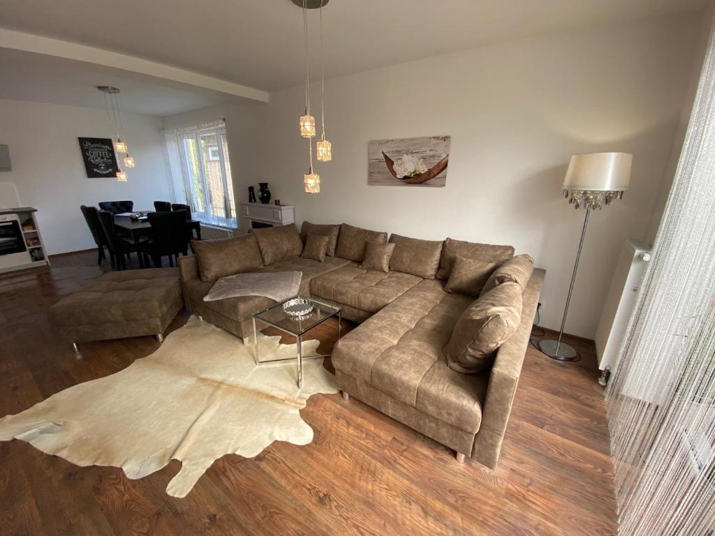 a living room with a couch and a table at ROYAL OCEAN Ferienhaus mit Sauna, Spielekonsole und Whirlpool in Rostock