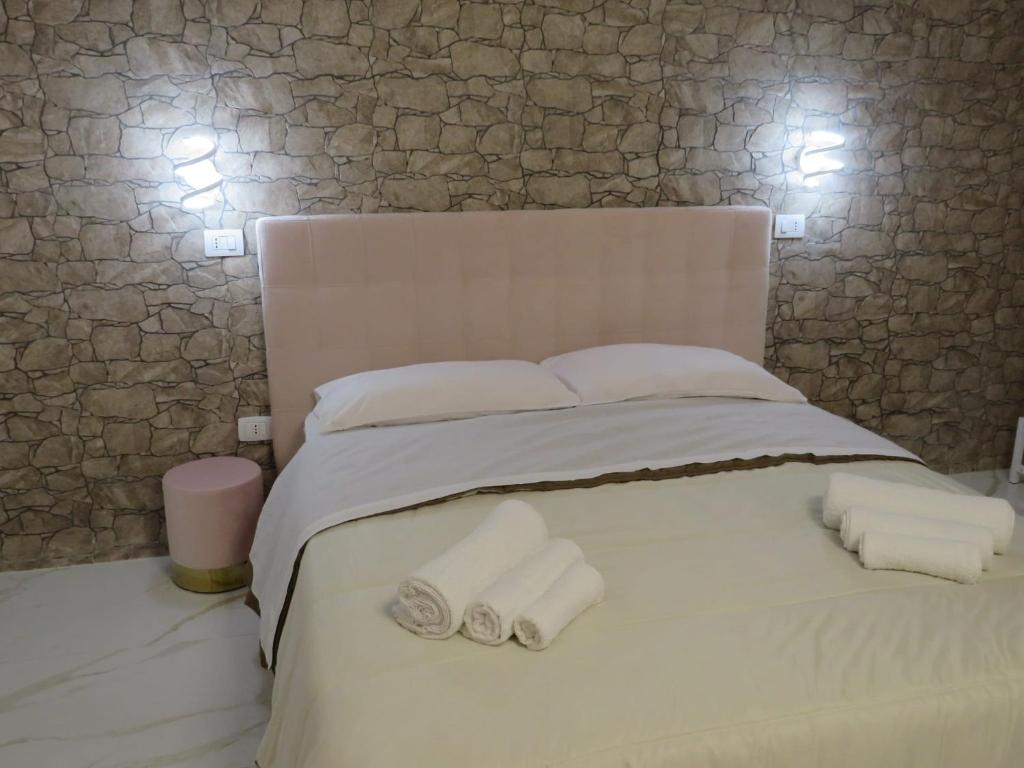 a white bed with two rolled towels on it at Tortora house in Naples