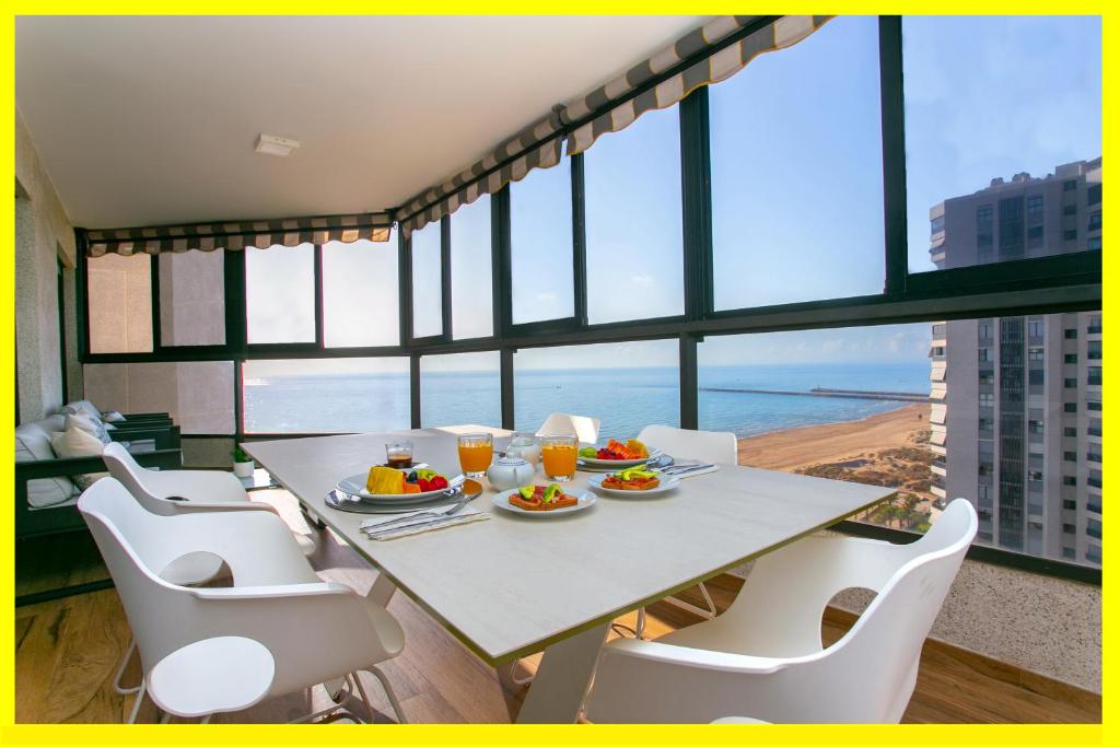 a dining room with a table with a view of the ocean at Cullera Beach Apartment Espacio in Cullera