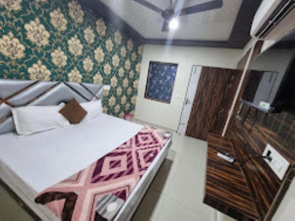 1 dormitorio pequeño con 1 cama y TV en Hotel Shanti Grand Inn , Gorakhpur en Gorakhpur