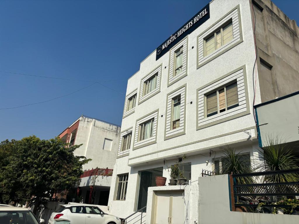 a white building with a sign on the side of it at Majestic Heights Hotel in Jaipur