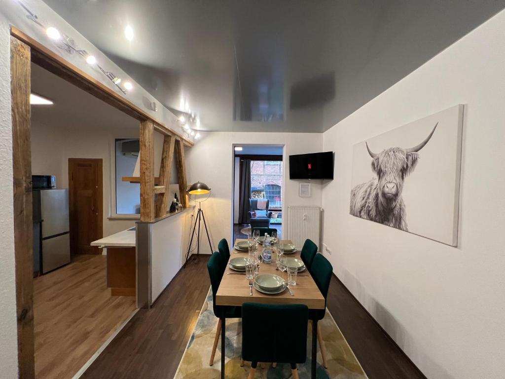 a dining room with a table and a picture of a cow at Apartment Humboldt 3 Schlafzimmer,Wifi, Netflix Parken, Terrasse, klimatisiert, nähe Zentrum in Jena