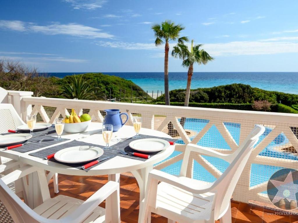 a white table and chairs on a balcony with the ocean at Apartamento 4 en primera linea de mar in Santo Tomás