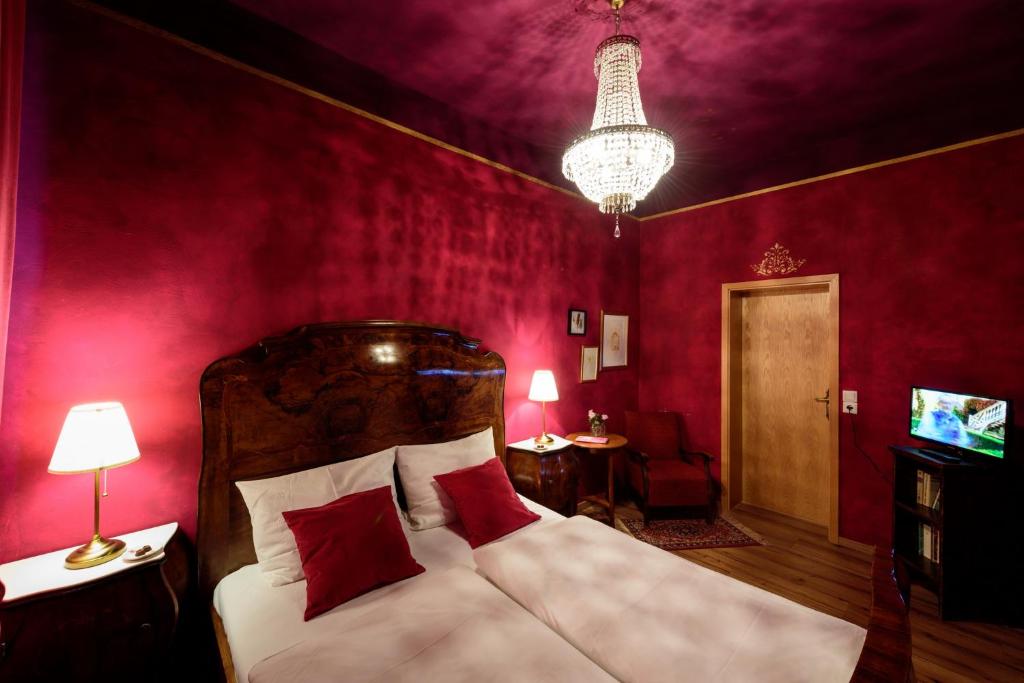 Schlafzimmer mit roten Wänden und einem Bett mit roten Kissen in der Unterkunft Kleine13 (Hohe13) in Quedlinburg