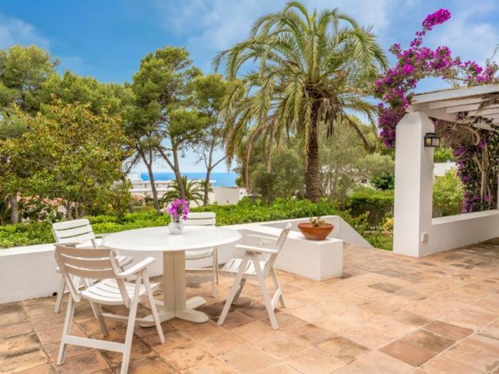a white table and chairs on a patio with the ocean at VILLA TOITA E19 con piscina privada in Santo Tomás