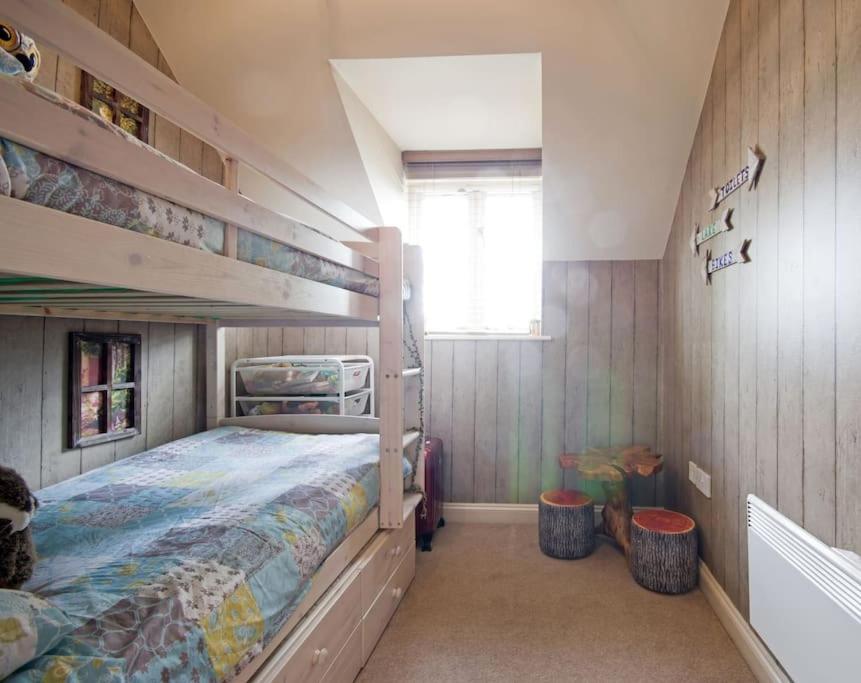 a bedroom with a bunk bed and two shelves at Cotswold Cottage Sleeps 7 pool/sports/spa/walks in Somerford Keynes