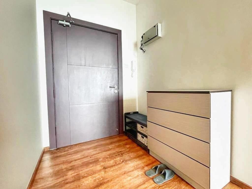 Cozy Homestay Vivacity Megamall في كوتشينغ: غرفة مع خزانة مع باب وأرضيات خشبية