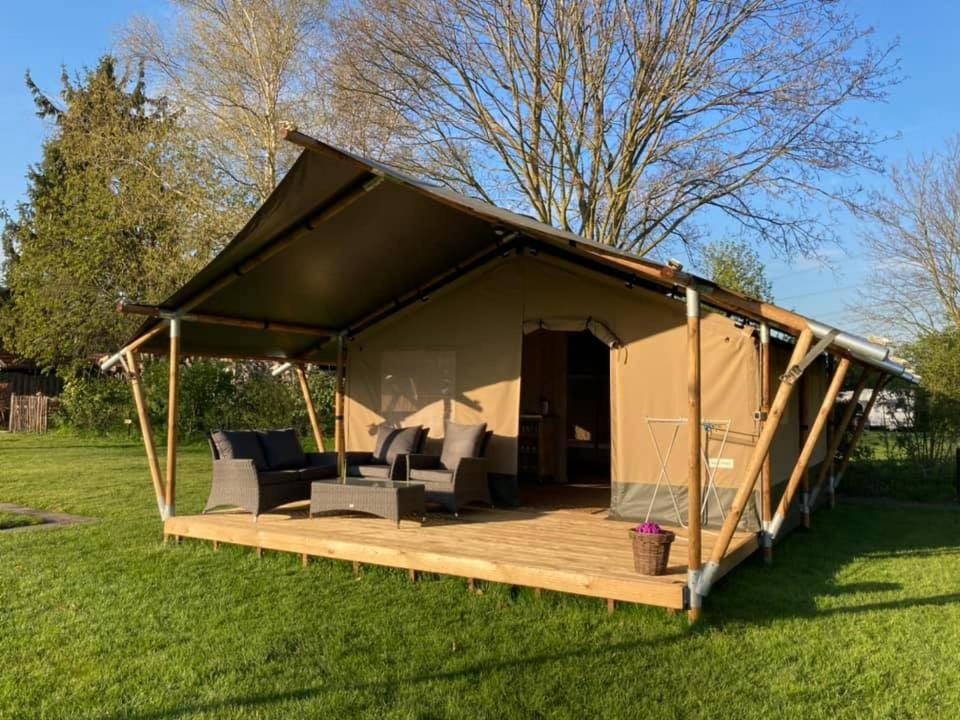 a tent with a deck in the grass at Camping de Peelweide in Grashoek