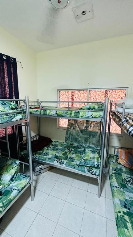 Cette chambre comprend 3 lits superposés. dans l'établissement SUNSHINE BOYS HOSTEL, à Dubaï