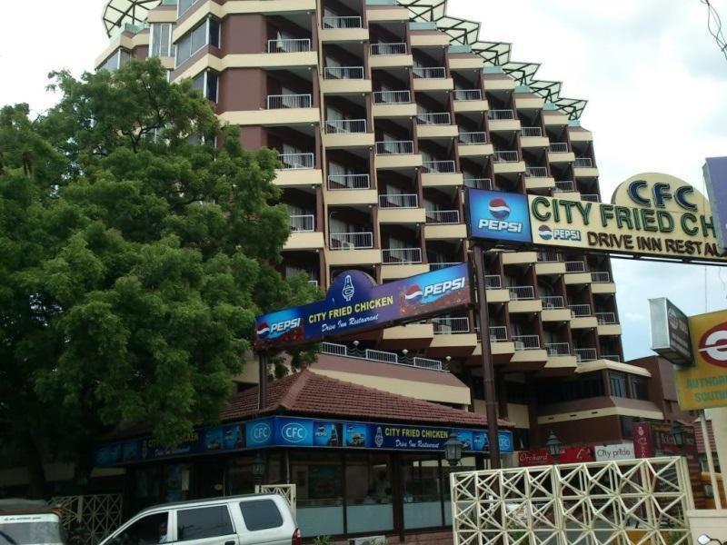 un gran edificio de apartamentos con un cartel delante en Hotel City Tower, en Coimbatore