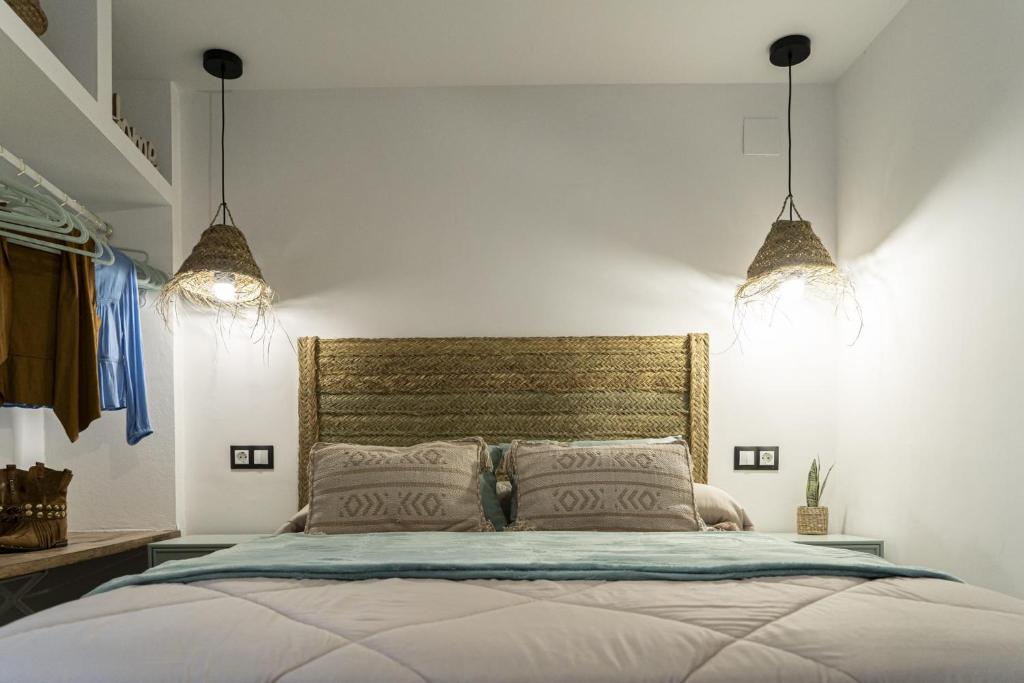 um quarto com uma cama grande e 2 luzes em U LAGARTU em Eljas