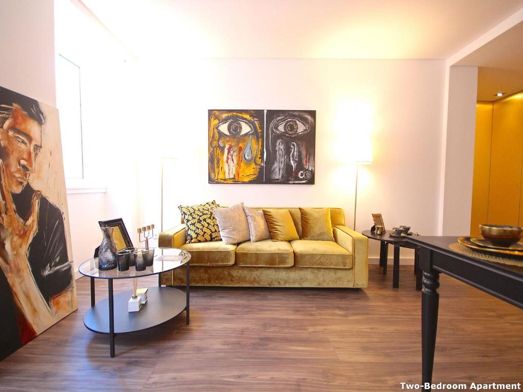 ein Wohnzimmer mit einem Sofa und 2 Tischen in der Unterkunft Akicity Liberdade Star in Lissabon