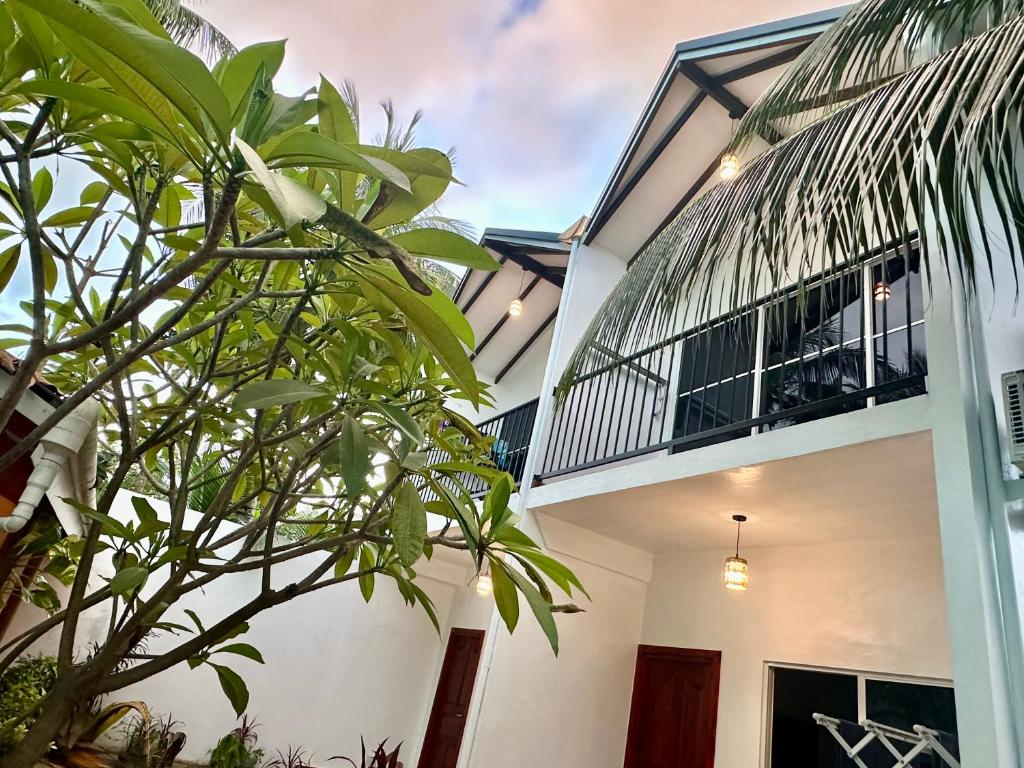een huis met een balkon en een palmboom bij Thoddoo Island Life in Thoddoo