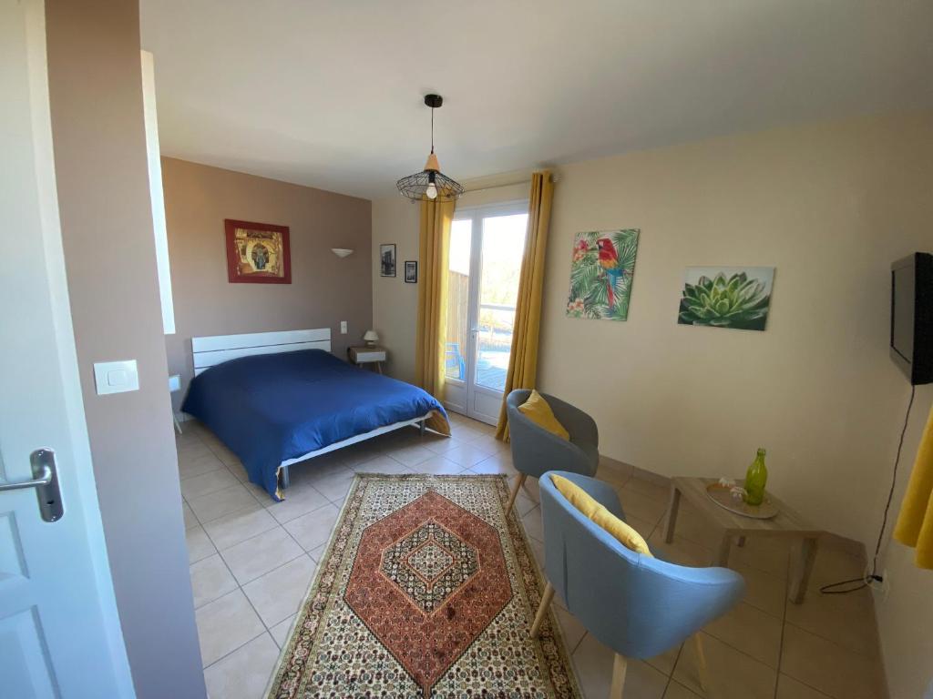 a bedroom with a blue bed and a window at VAL ST GEORGES in Saint-Georges-de-Luzençon