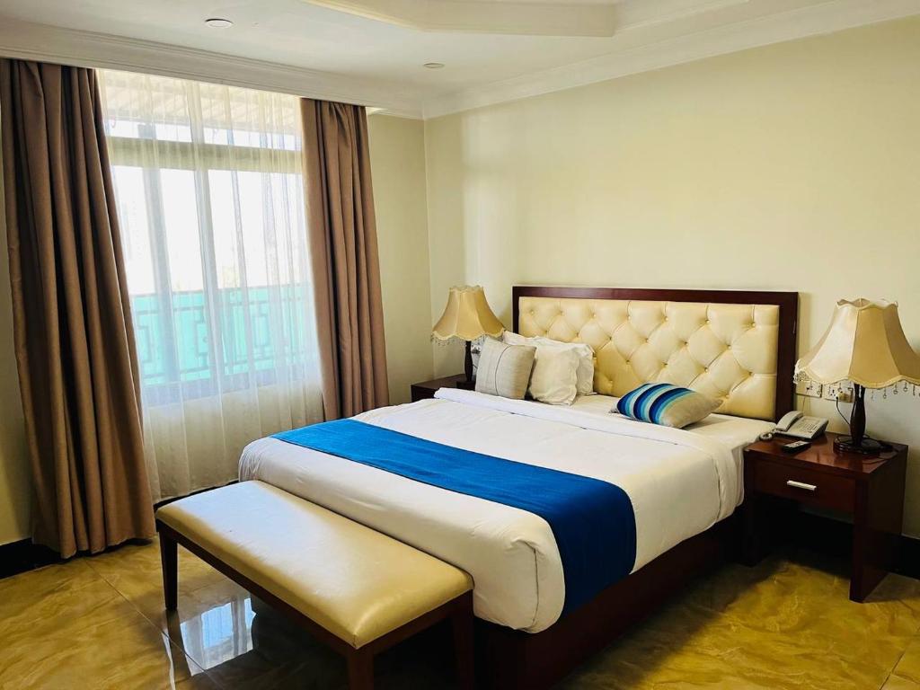 a hotel room with a large bed and a window at Tolip Olympia Hotel in Addis Ababa