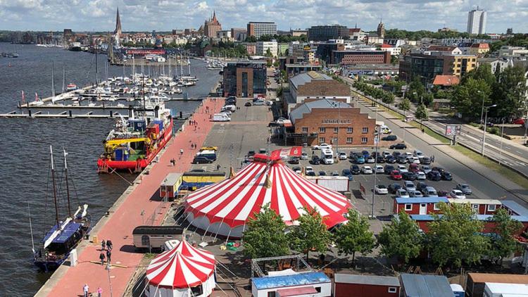 a marina with a red and white tent next to the water at Circus Fantasia in Rostock