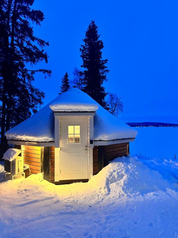 une petite étable dans la neige la nuit dans l'établissement Northernlight cabin 2, à Kiruna