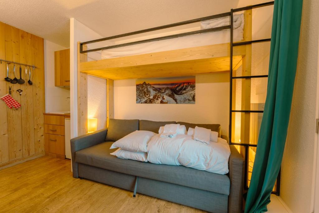 a loft bed in a room with a couch at Chamonix Sud - Forclaz 304 - Happy Rentals in Chamonix