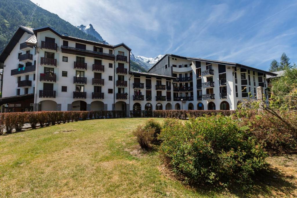 a large building with a grassy field in front of it at Chamonix Sud - Forclaz 304 - Happy Rentals in Chamonix
