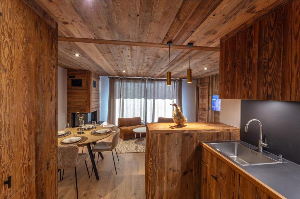 a kitchen with a table and a cat sitting on a counter at Modern apartment in Megeve near ski lifts in Megève