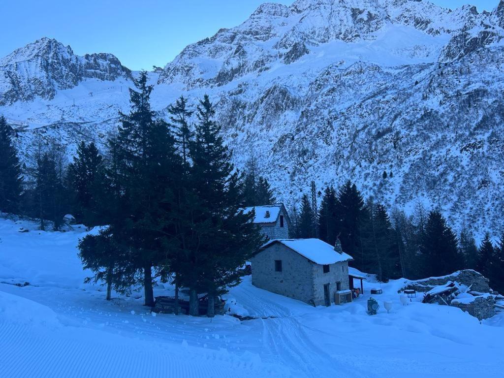 una casa en la nieve con una montaña en Chalet Baita Aria, en Ponte di Legno
