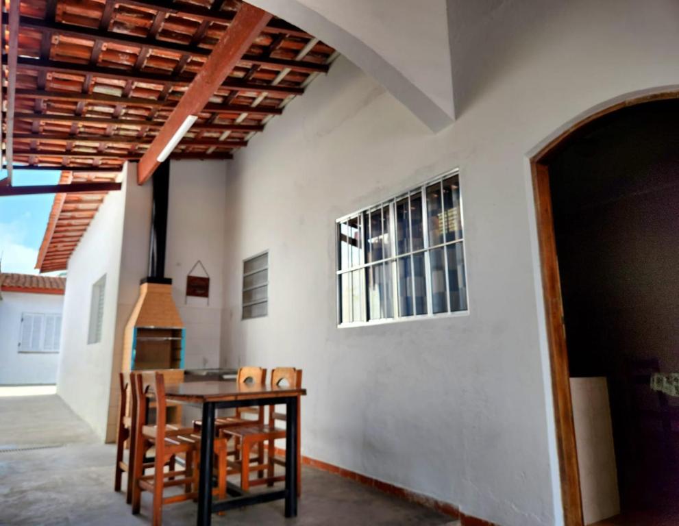 a dining room with a table and chairs and a window at Casa no Centro 600m da Praia in Bertioga