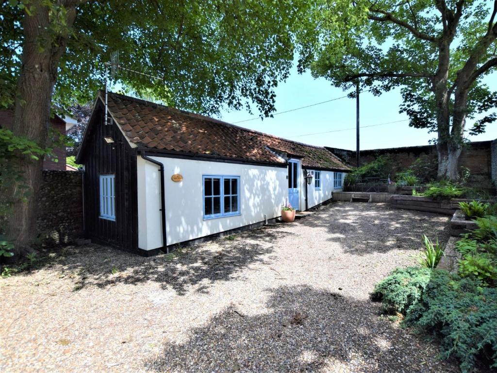 a small white and black house with a driveway at 1 Bed in Cley NCC04 in Cley next the Sea