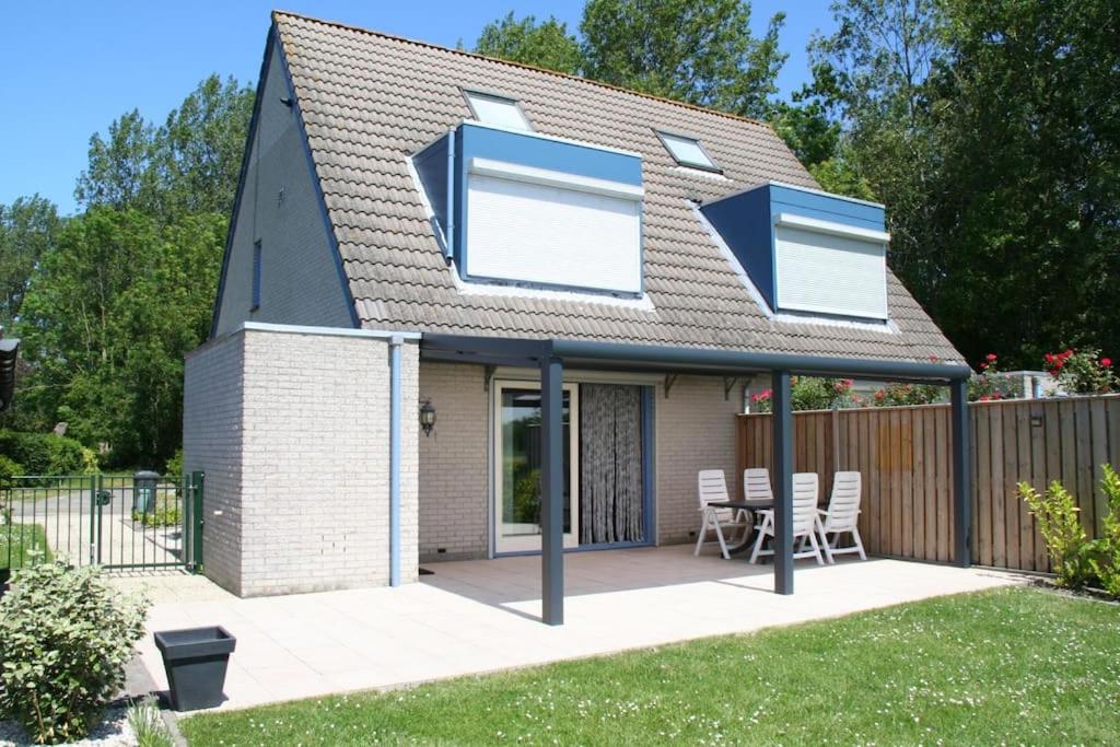 ein Haus mit 3 Fenstern und einer Terrasse in der Unterkunft Lamsoor 26* in Nieuwvliet