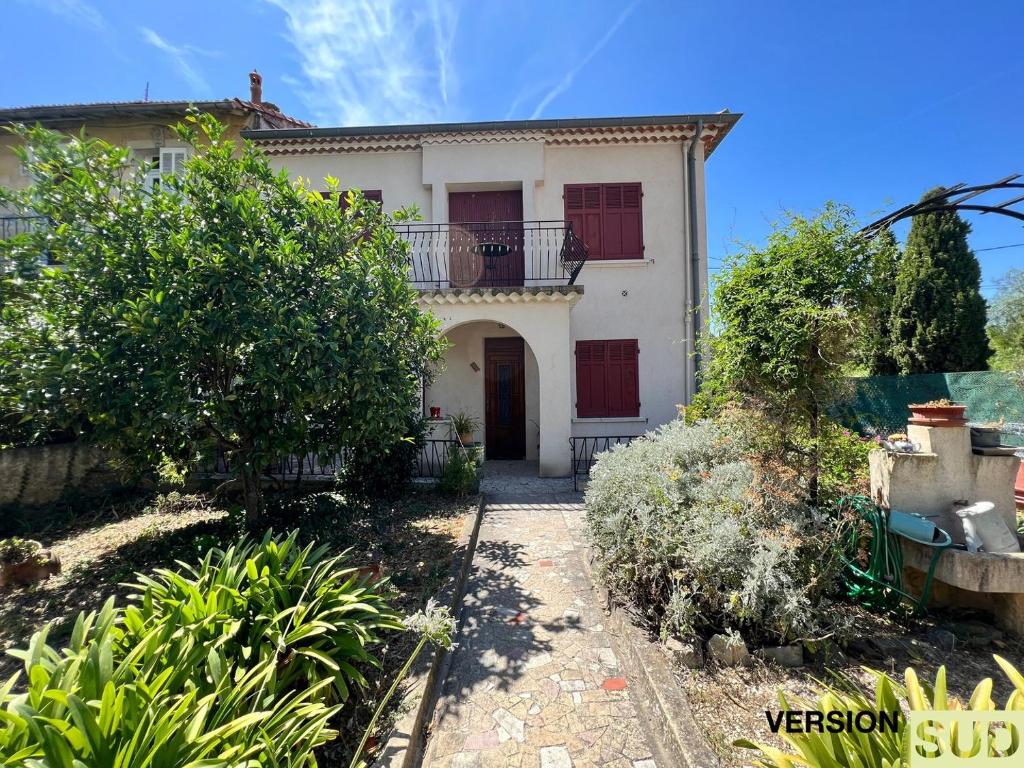 ein weißes Haus mit einem Balkon und einer Auffahrt in der Unterkunft Version SUD Lumineuse Bas Maison avec jardin in Toulon