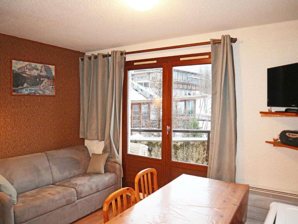 uma sala de estar com um sofá e uma mesa em Appartement Les Orres, 1 pièce, 4 personnes - FR-1-322-122 em Les Orres
