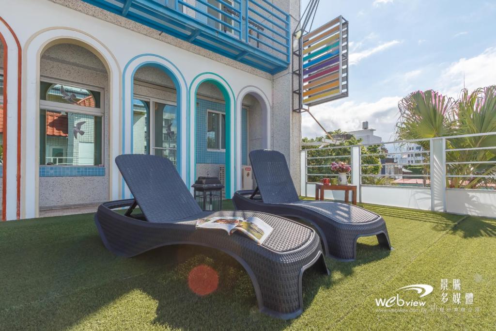 two chairs sitting on a lawn in front of a house at Sweet Rainbow B&amp;B in Hualien City
