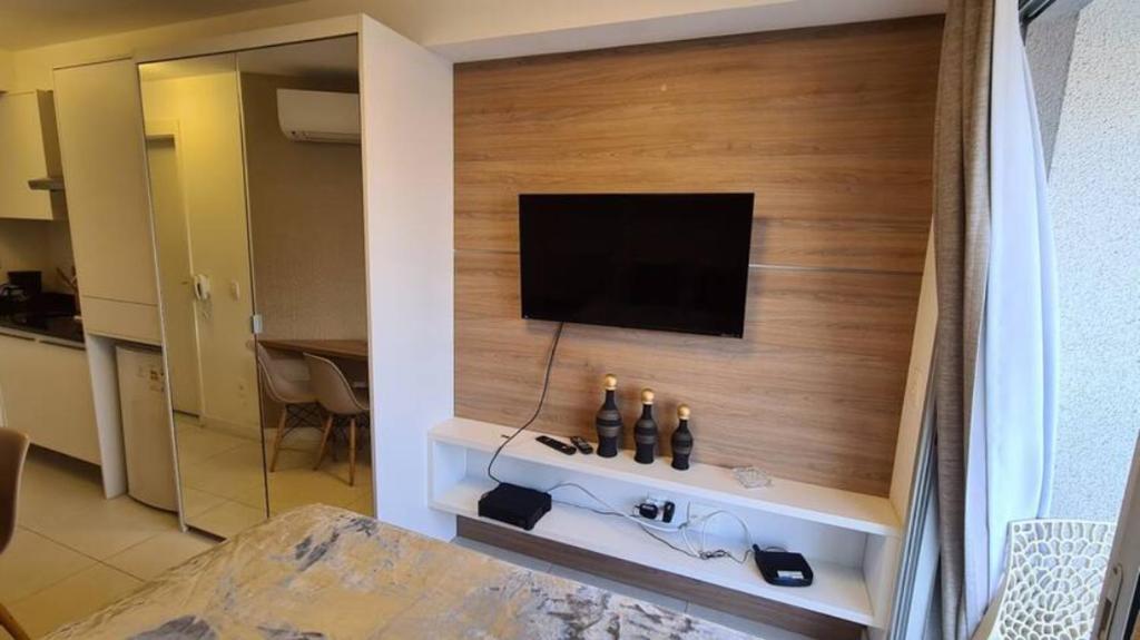 a living room with a television on a wall at Wize in Sao Paulo