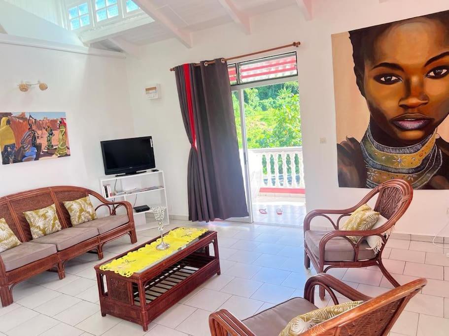 ein Wohnzimmer mit einem großen Gemälde einer schwarzen Frau in der Unterkunft Terrasse des Manguiers : logement indépendant in Pointe-Noire