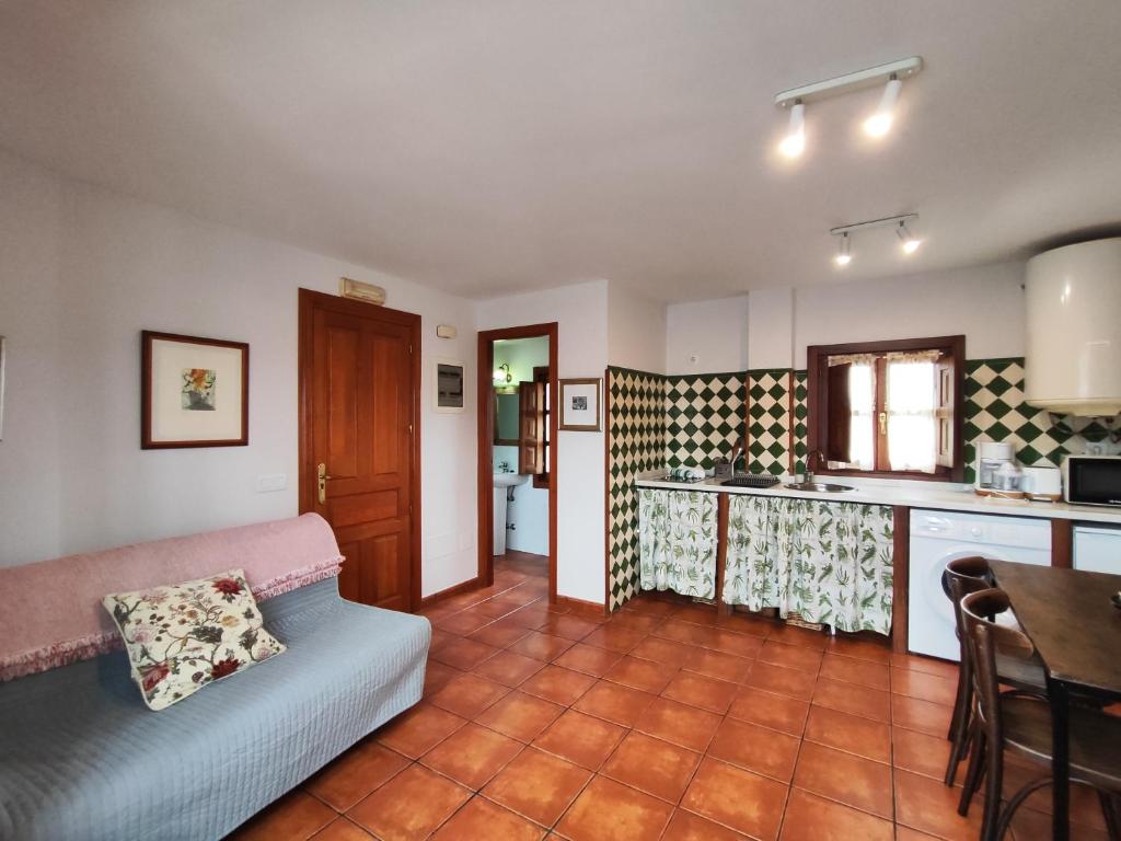 ein Wohnzimmer mit Sofa und eine Küche in der Unterkunft La Tienda de Porrúa in Llanes
