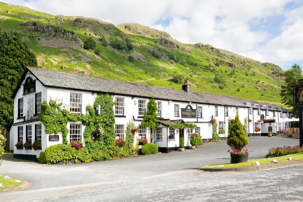 a row of white buildings with a hill in the background at The King's Head in Thirlmere