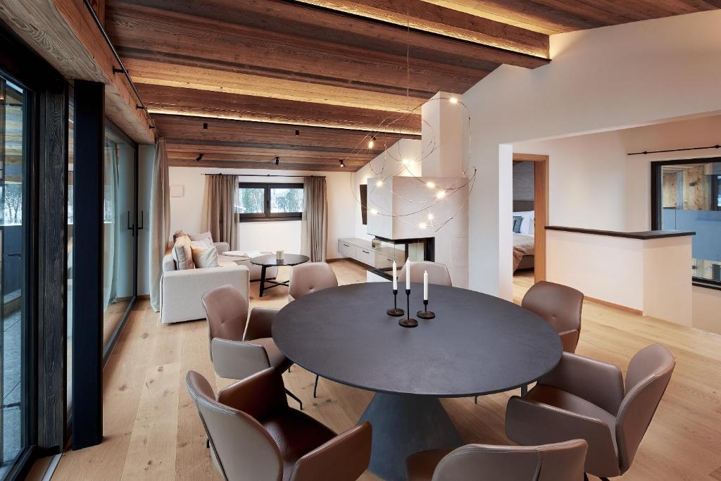 a dining room and living room with a table and chairs at Alpin Residenzen Eichenheim Aurach bei Kitzbühel by Alpina-Holiday in Aurach bei Kitzbuhel