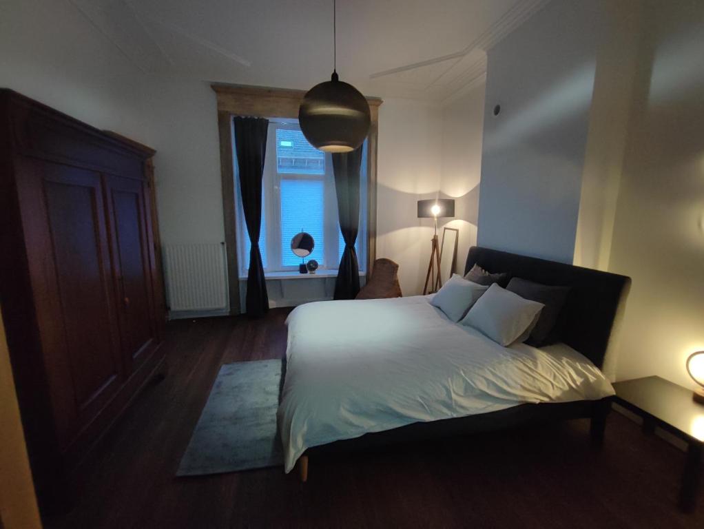 a bedroom with a white bed and a window at Le Liégeois - proche centre - Maison de maître in Liège