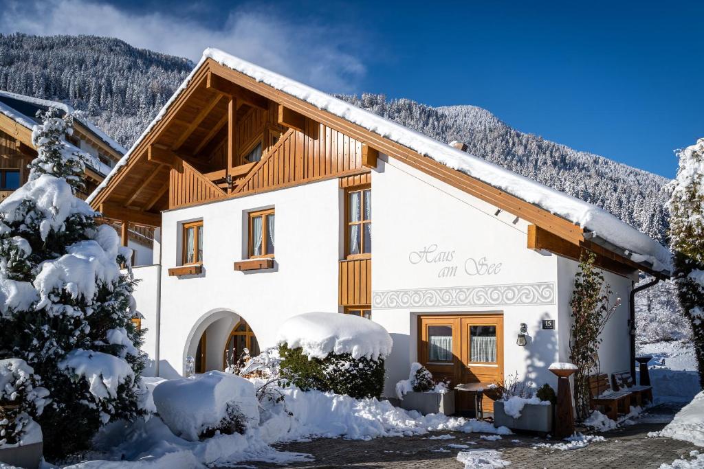 a house covered in snow in the mountains at Ferienhaus am Burgsee in Ladis